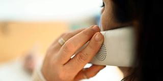 Eine Frau hält sich den Telefonhörer ans Ohr (Foto: picture alliance/dpa | Uli Deck)