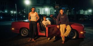 Die drei Jungs von 01099 posen mit einem Auto. (Foto: Arida Flack)