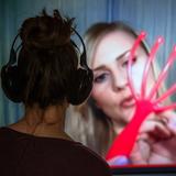 Ein Mädchen verfolgt vor einem Internet-Monitor eine Folge der ASMR-Sendung "Gentle Whispering" auf einem YouTube Kanal. (Foto: dpa)