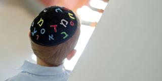 Ein jüdischer Schüler trägt eine Kippa mit hebräischen Schriftzeichen (Foto: picture alliance / Daniel Bockwoldt/dpa)