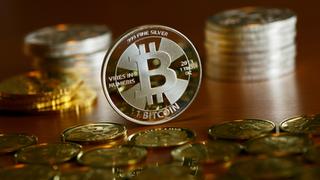 Münzen mit dem Aufdruck "Bitcoin" stehen und liegen auf einem Tisch.  (Foto: picture alliance / Jens Kalaene/dpa-Zentralbild/dpa | Jens Kalaene)