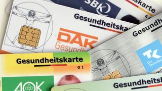 Gesundheitskarten verschiedener Krankenkassen liegen auf einem Tisch.  (Foto: picture alliance / Jens Kalaene/dpa-Zentralbild/dpa)