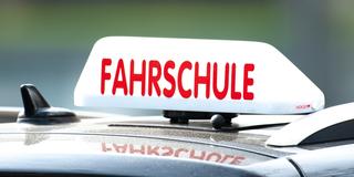 Ein Auto mit einem Schild auf dem "Fahrschule" steht (Foto: dpa)