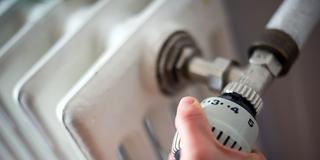 Eine Hand greift zum Heizungsthermostat (Foto: dpa/Ole Spata)