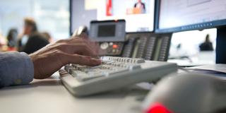 Ein Mann tippt einem Büro auf einer Tastatur. (Foto: picture alliance/dpa | Daniel Naupold)