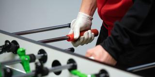 Ein Tischfußball-Profi spielt mit einem Lederhandschuh (Foto: picture alliance/dpa | Daniel Reinhardt)