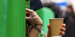Eine Frau hält einen Getränkebecher aus Pappe in der Hand (Foto: picture alliance/dpa | Aaron Chown)