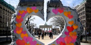 Durch den herzförmigen Ausschnitt einer Nachbildung der Berliner Mauer aus Kunststoff ist das Brandenburger Tor zu sehen. (Foto: picture alliance/dpa | Britta Pedersen)