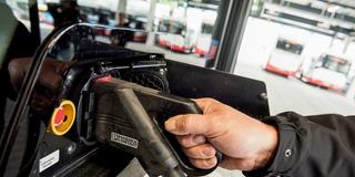 Ein Busfahrer schließt ein Ladekabel an einen Elektrobus (Foto: picture alliance/dpa | Daniel Bockwoldt)