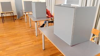 Eine Frau sitzt in einer Wahlkabine. (Foto: dpa / Stefan Sauer)