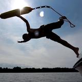 Ein Rettungsschwimmer der DLRG springt von einem Bott in bei einer Übung in einen See. (Foto: dpa)