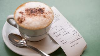 Ein Kassenzettel liegt neben einer Tasse mit Kakao (Foto: dpa/)