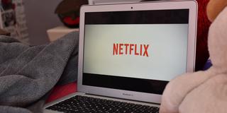 Ein Laptop, auf dem Netflix geöffnet ist, steht auf einem Bett (Foto: pixabay.com/Jade87)