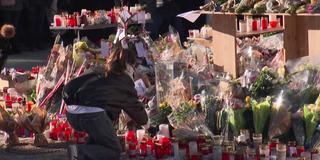 June Frau legt Blumenstrauß an Gedenkstätte zu den Opfer der Brandatastrophe in Cran Montana nieder (Foto: SR)