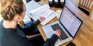 Eine junge Frau sitzt am Laptop und macht ihre Steuererklärung (Foto: picture alliance / dpa-tmn | Benjamin Nolte)