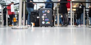 Eine Familie steht mit ihrem Gepäck am Flughafen in der Warteschlange für einen Corona-Test, während auf dem Koffer eine britische Flagge mit dem Schriftzug „London“ zu sehen ist. (Foto: dpa/Jonas Güttler)
