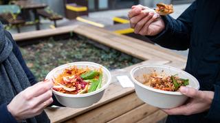 Ein Mann und eine Frau nehmen ihr Mittagessen aus einer Einwegverpackung zu sich.  (Foto: picture alliance/dpa | Bernd von Jutrczenka)