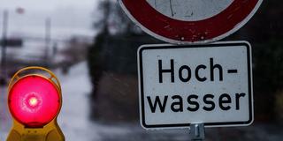 Ein Hochwasserschild und eine Absperrbarke (Foto: picture alliance/dpa | Andreas Arnold)