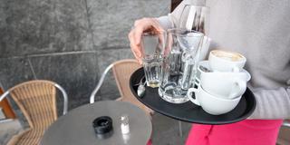 Ein Kellner räumt einen Tisch in einem Restaurant ab.  (Foto: picture alliance/dpa | Sebastian Gollnow)