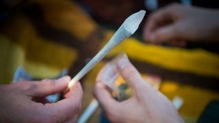 Ein junger Mann hält einen Joint in der Hand. (Foto: picture alliance/dpa | Arne Immanuel Bänsch)