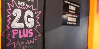 «Hier: 2G PLUS - Nur mit extra Test!» steht auf einem Schild an der geschlossenen Tür einer Bar in der Innenstadt. (Foto: picture alliance/dpa | Daniel Karmann)