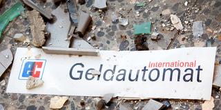 Das Schild eines Geldautomaten liegt neben Glasscherben auf dem Boden. (Foto: picture alliance/dpa/dpa-Zentralbild | Patrick Pleul)