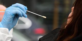 Eine Mitarbeiterin nimmt einen Abstrich von einer Patientin (Foto: picture alliance/dpa | Julian Stratenschulte)