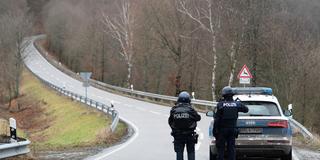 Polizeibeamte stehen am 31.01.2022 an einer Absperrung an der Kreisstraße 22 rund einen Kilometer von dem Tatort an dem zwei Polizeibeamte durch Schüsse getötet wurden. (Foto: picture alliance/dpa | Sebastian Gollnow)