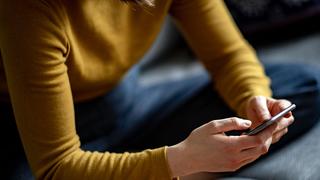 Eine junge Frau hält ein Smartphone in der Hand (Foto: picture alliance/dpa | Fabian Sommer)