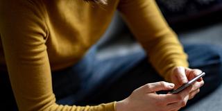 Eine junge Frau hält ein Smartphone in der Hand (Foto: picture alliance/dpa | Fabian Sommer)