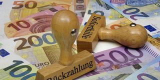 Symbolbild. Auf Geldscheinen stehen Stempel mit den Schriftzügen Soforthilfe und Rückzahlung. (Foto: picture alliance / ZB | Sascha Steinach)