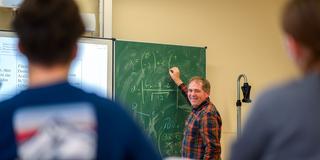 Ein Mathematiklehrer im Unterricht vor seiner Klasse (Foto: picture alliance/dpa/dpa-Zentralbild | Robert Michael)