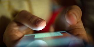 Ein junger Mensch hält ein Smartphone in Händen (Foto: picture alliance/dpa | Sebastian Gollnow)