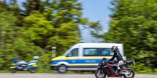 Ein Motorrad fährt an Einsatzfahrzeugen der Polizei vorbei (Foto: picture alliance/dpa | Philipp von Ditfurth)