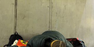 Ein Obdachloser liegt auf dem Boden in einer Unterführung (Foto: picture alliance / dpa | Barbora Prekopova)