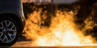 Abgase kommen im Gegenlicht der aufgehenden Sonne aus dem Auspuff eines Autos (Foto: picture alliance/dpa | Marcel Kusch)