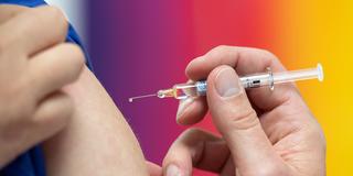 Eine Spritze mit Schutzimpfung vor einem Kinder-Arm (Foto: picture alliance/dpa | Sebastian Kahnert)
