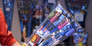 Ein Verkäufer reicht in einem Geschäft Raketen über die Ladentheke. (Foto: picture alliance / dpa | Britta Pedersen)