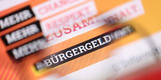«Bürgergeld» ist auf der Homepage des Bundesministeriums für Arbeit und Soziales durch eine Brille zu lesen.  (Foto: picture alliance/dpa | Karl-Josef Hildenbrand)