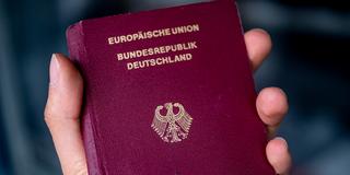 Eine Person hält einen Pass der Bundesrepublik Deutschland in der Hand. (Foto: picture alliance/dpa | Fabian Sommer)