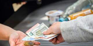 Eine Kassiererin gibt einer Kundin Wechselgeld an der Kasse eines Supermarktes (Foto: picture alliance/dpa | Julian Stratenschulte)