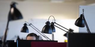 Ein Mann arbeitet am Computer in einem Büro mit zahlreichen Arbeitsplätzen (Foto: picture alliance/dpa | Sebastian Gollnow)