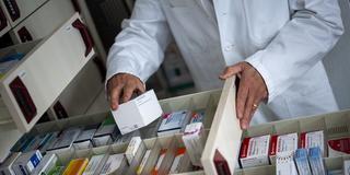 Ein Apotheker holt eine Medikamentenverpackung aus einer Schublade in einer Apotheke.  (Foto: picture alliance/dpa | Monika Skolimowska)