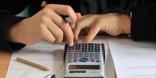 Ein Schüler sitzt vor einem Taschenrechner (Foto: picture alliance / dpa | Hendrik Schmidt)