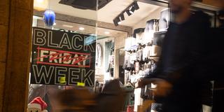 Menschen gehen an einem Schaufenster mit Rabatt-Aktionen vorbei (Foto: picture alliance/dpa | Clara Margais)