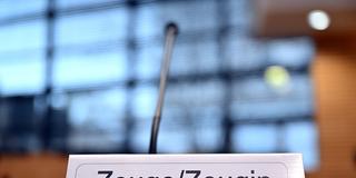 Ein Schild mit der Aufschrift «Zeuge/Zeugin» steht auf einem Tisch. (Foto: picture alliance/dpa | Martin Schutt)