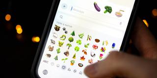 Eine Person wählt verschiedene Emoijis auf dem Smartphone aus.  (Foto: SR/picture alliance/dpa | Sina Schuldt)
