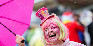 Eine verkleidete Närrin lacht herzlich mit einem Schirm in der Hand (Foto: picture alliance/dpa | Rolf Vennenbernd)