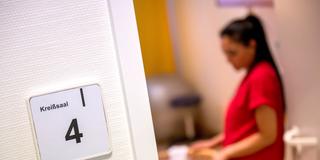 Eine Hebamme steht an einem Bett im Kreißsaal. (Foto: picture alliance/dpa | Sina Schuldt)