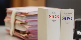 Gerichtsakten und Bücher zu Strafgesetzbuch und Strafprozessordnung liegen bzw. stehen liegen auf einem Tisch im Gericht (Foto: picture alliance/dpa | David Young)